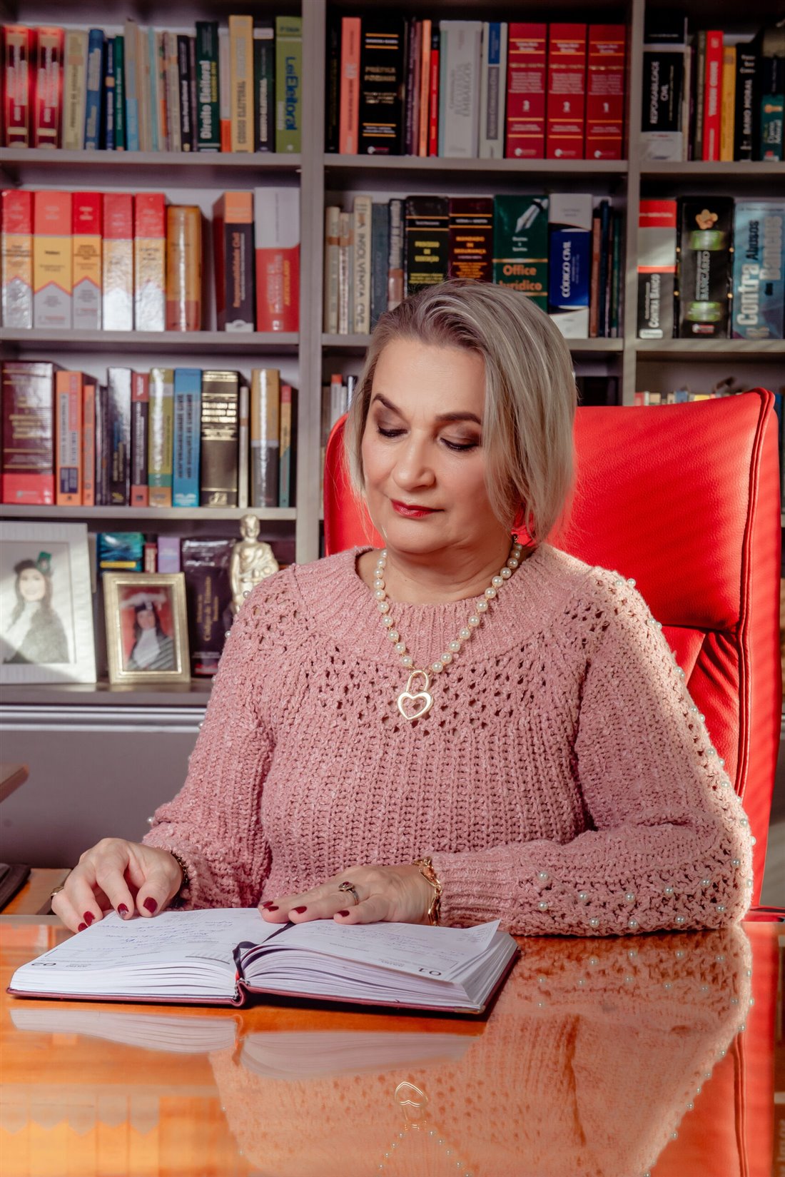 Dra. Rosana em seu escritório, diante de sua biblioteca